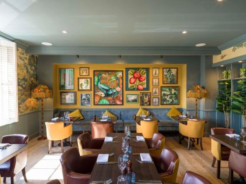 a restaurant with tables and chairs and paintings on the wall at The Kings Arms in Christchurch