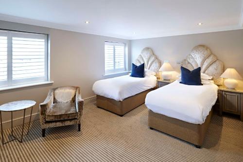 a hotel room with two beds and a chair at The Kings Arms in Christchurch