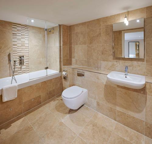a bathroom with a toilet and a sink and a tub at The Kings Arms in Christchurch