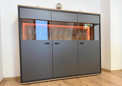 a large glass cabinet with wine glasses in it at Gemütlich, OLED-TV & XXL-Küche, familienfreundlich in Schlitz