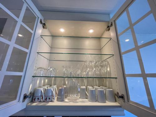 a glass shelf with glasses on it in a window at 83m2-3 sleeping rooms-2 balconies-direct traffic to airport and tourist places in Bergen