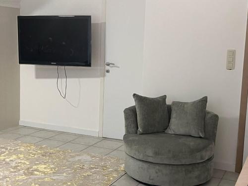 a living room with a chair and a flat screen tv at Luxe Villa Lou & Hans in Aalst
