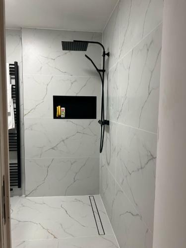a bathroom with a shower with white marble walls at Luxe Villa Lou & Hans in Aalst