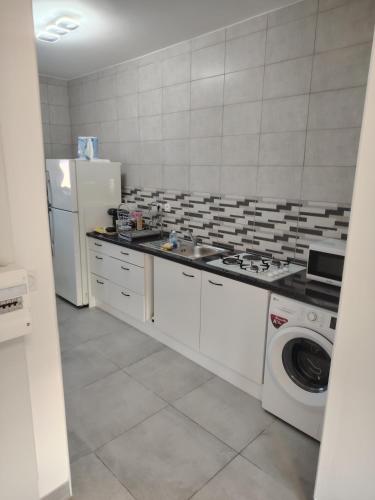 une cuisine avec un réfrigérateur et une machine à laver dans l'établissement Joli appartement F3 proche transport, à Vénissieux