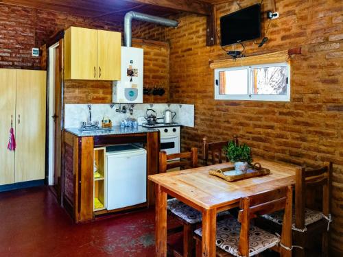 een keuken en eetkamer met een tafel en een fornuis bij Quebrada del Viento - Cabañas in Los Hornillos