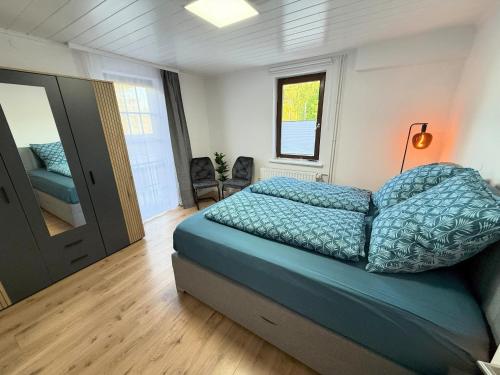 a bedroom with a bed with a blue comforter at Gemütlich, OLED-TV & XXL-Küche, familienfreundlich in Schlitz