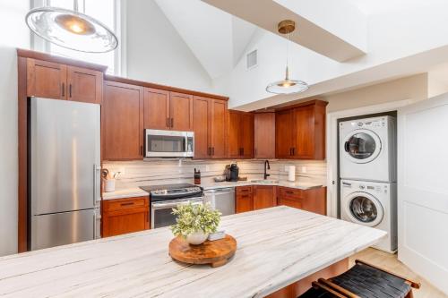 a kitchen with wooden cabinets and a wooden table at The Newport Lofts - 543 Thames Street in Newport