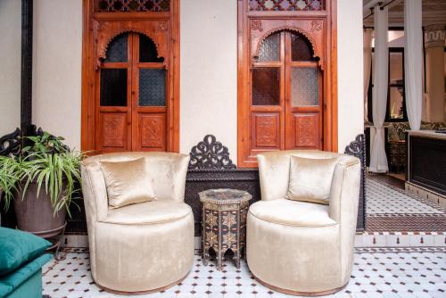deux chaises et une table devant un bâtiment dans l'établissement Riad El Wiam, à Marrakech