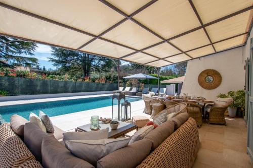 un patio extérieur avec des canapés et une piscine dans l'établissement Villa Warica, à Valbonne