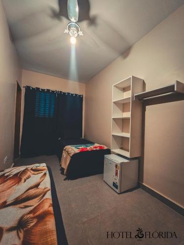 a bedroom with a bed and a ceiling fan at Hotel Flórida, Triplo - 08 in Poços de Caldas