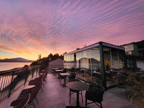a patio with tables and chairs with a sunset at Sempione Boutique Hotel in Stresa