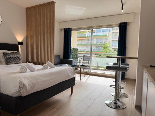 une chambre d'hôtel avec un lit et une grande fenêtre dans l'établissement Cosy Appartement, Centre-ville Cannes, Terrasse, Clim, à Cannes