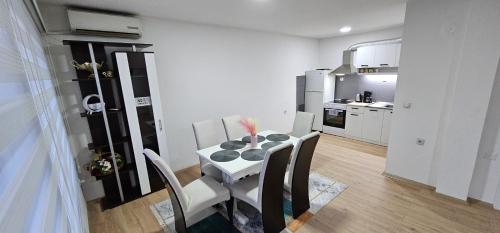 una cucina con un tavolo e sedie in una stanza di Property Sim-Vlae a Skopje