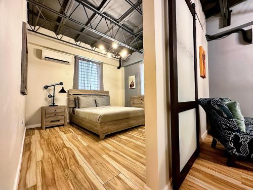 a bedroom with a bed and a chair in a room at The Lofts At Santurce in San Juan