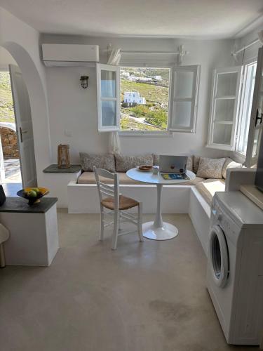 a white living room with a table and a couch at Blue and white Mykonos in Mikonos