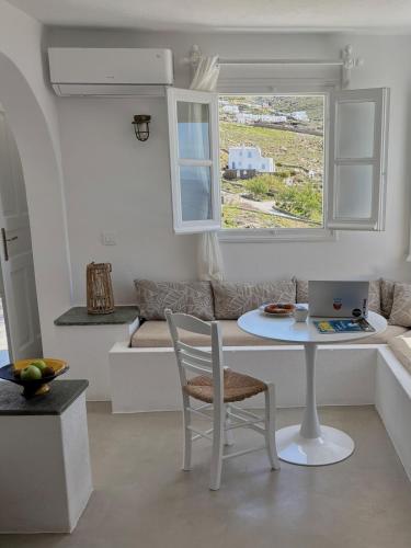 a white living room with a table and a laptop at Blue and white Mykonos in Mikonos