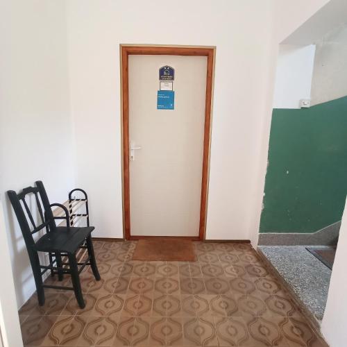 a hallway with a door and a chair and a chair at Panonka apartman in Leskovac