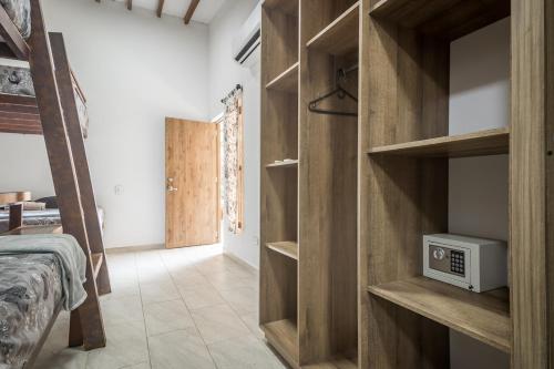 a bedroom with wooden shelves and a bed with a microwave at Monteclaro Campestre - En Sopetran in Sopetran