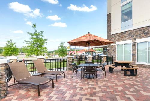 a patio with a table and chairs and an umbrella at Hyatt Place Canton in Lake Cable