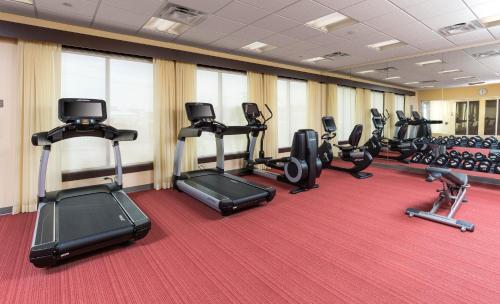 a gym with several treadmills and elliptical machines at Hyatt Place Canton in Lake Cable