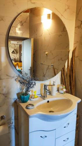 a bathroom with a sink and a mirror at Stonehouse Olivelia - Afrathias Beach in Tympáki