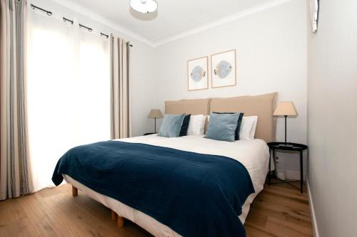 une chambre avec un grand lit avec une couverture bleue dans l'établissement Villa Warica, à Valbonne