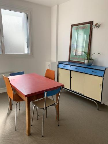 une pièce avec une table, des chaises et une commode bleue dans l'établissement T2 Bourg de Vertou Appartement, à Vertou