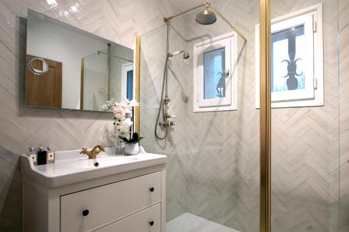 une salle de bain blanche avec une douche et un lavabo dans l'établissement Villa Warica, à Valbonne