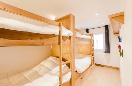 une chambre avec deux lits superposés dans l'établissement La Plane - Les Tanières de Montgenèvre - Appartement 8p front de neige, à Montgenèvre