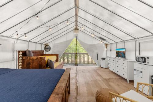a bedroom in a greenhouse with a bed and a tv at Red River Elusive Elk Glamping Tent 1 in Stanton