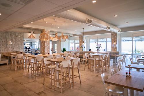 a restaurant with wooden tables and chairs and windows at Sand Dunes Resort and Suites in Myrtle Beach