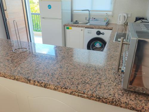 a kitchen with a counter top with a washing machine at Sunset Green 02 in Paphos City