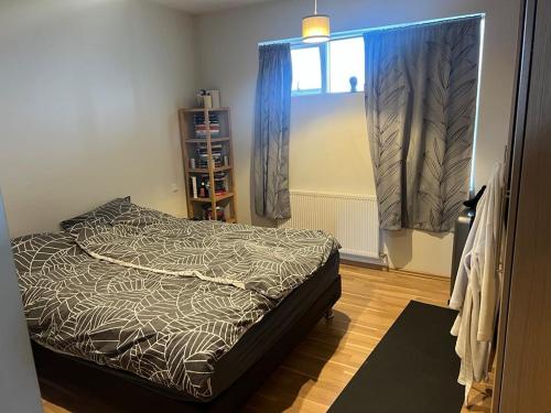 a small bedroom with a bed and a window at Austurkór in Garðakauptún
