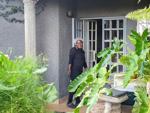 a woman standing in front of a house at Belvedere-on-River in Malelane