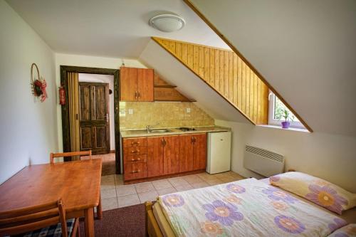 een keuken met een bed en een tafel in een kamer bij Pod Kolavou in Zdobnice