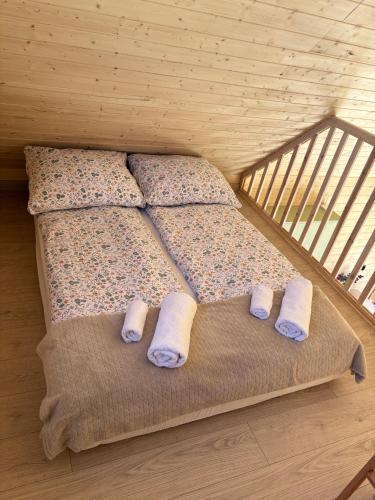 a bed in a room with slippers on it at PAKLADA Domek całoroczny 1 in Bak