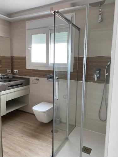 a bathroom with a toilet and a glass shower at Jerez Deluxe in Jerez de la Frontera