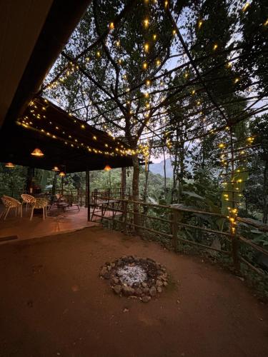 a patio with a bunch of lights hanging from a tree at Triloka by The Offbeat Crew in Munnar
