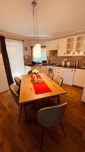 a dining room table with chairs and a kitchen at Strigonia Apartman in Esztergom