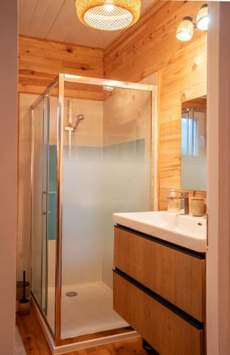 une salle de bain avec douche et lavabo dans l'établissement Chalet du Courlis, les cabanes océanes-MONTA, à Vendays-Montalivet