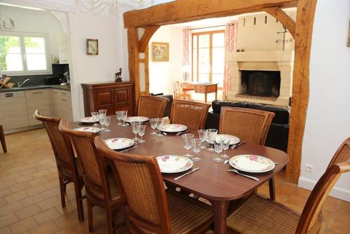 une salle à manger avec une table et des chaises et une cheminée dans l'établissement La maison Séquoia, à Gien