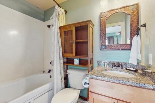 Un baño con lavabo, inodoro y espejo. en Gulfside Townhomes 7 by Meyer Vacation Rentals, en Gulf Shores