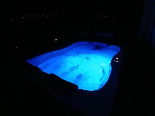 a blue pool of water at night at Villa Alexandros in Zóla