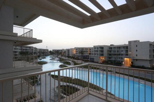 Una vista de una piscina desde el balcón de un edificio. en Emmar Marassi Marina views chalet, en El Alamein