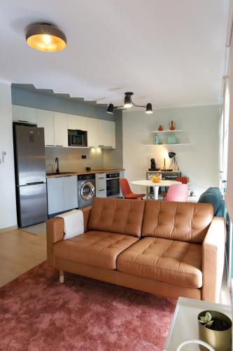 a living room with a brown couch and a kitchen at Dabney3 Apartments in Madalena