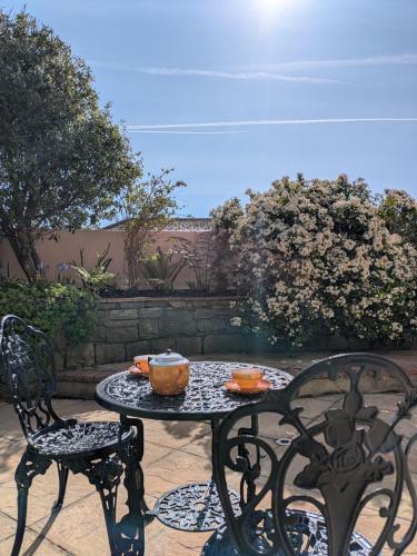 a table and two chairs with bowls on it at Garden studio near sea in Torquay