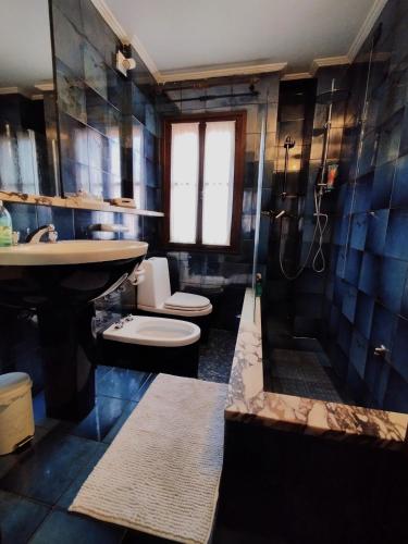 a bathroom with a shower and two toilets and a sink at Ca' del Bovolo in Chioggia