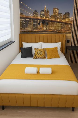 a bedroom with a large bed with yellow sheets and pillows at Przytulny apartament Brooklyn Centrum miasta Rzeszów - Podwisłocze 38 in Rzeszów