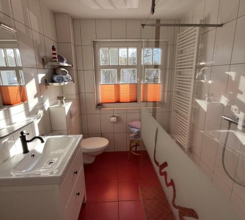 a bathroom with a sink and a toilet and a shower at Ferienhaus Laran in Zingst