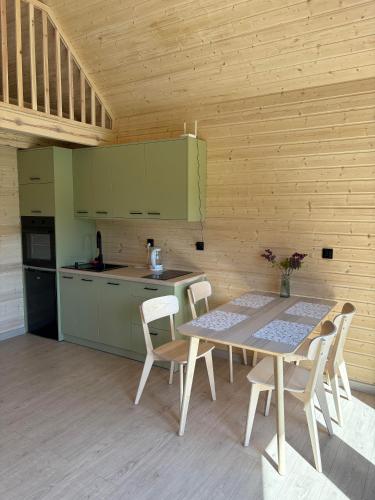 a kitchen with a table and chairs in a room at PAKLADA Domek całoroczny 1 in Bak